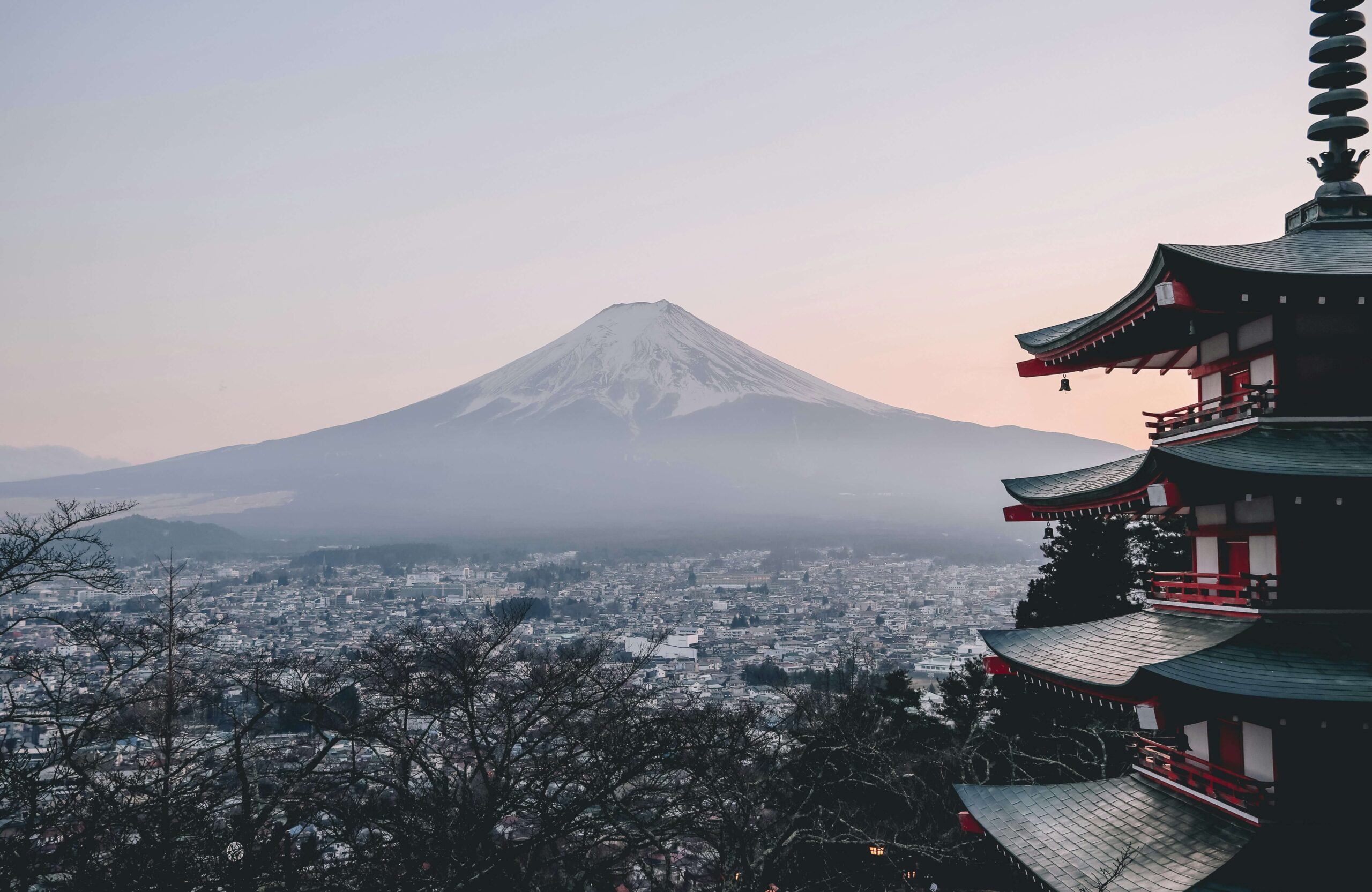 The serene image of Mount Fuji rising above a tranquil town with a multi-tiered pagoda in the foreground, symbolizing the iconic beauty of Japan and its culture.
