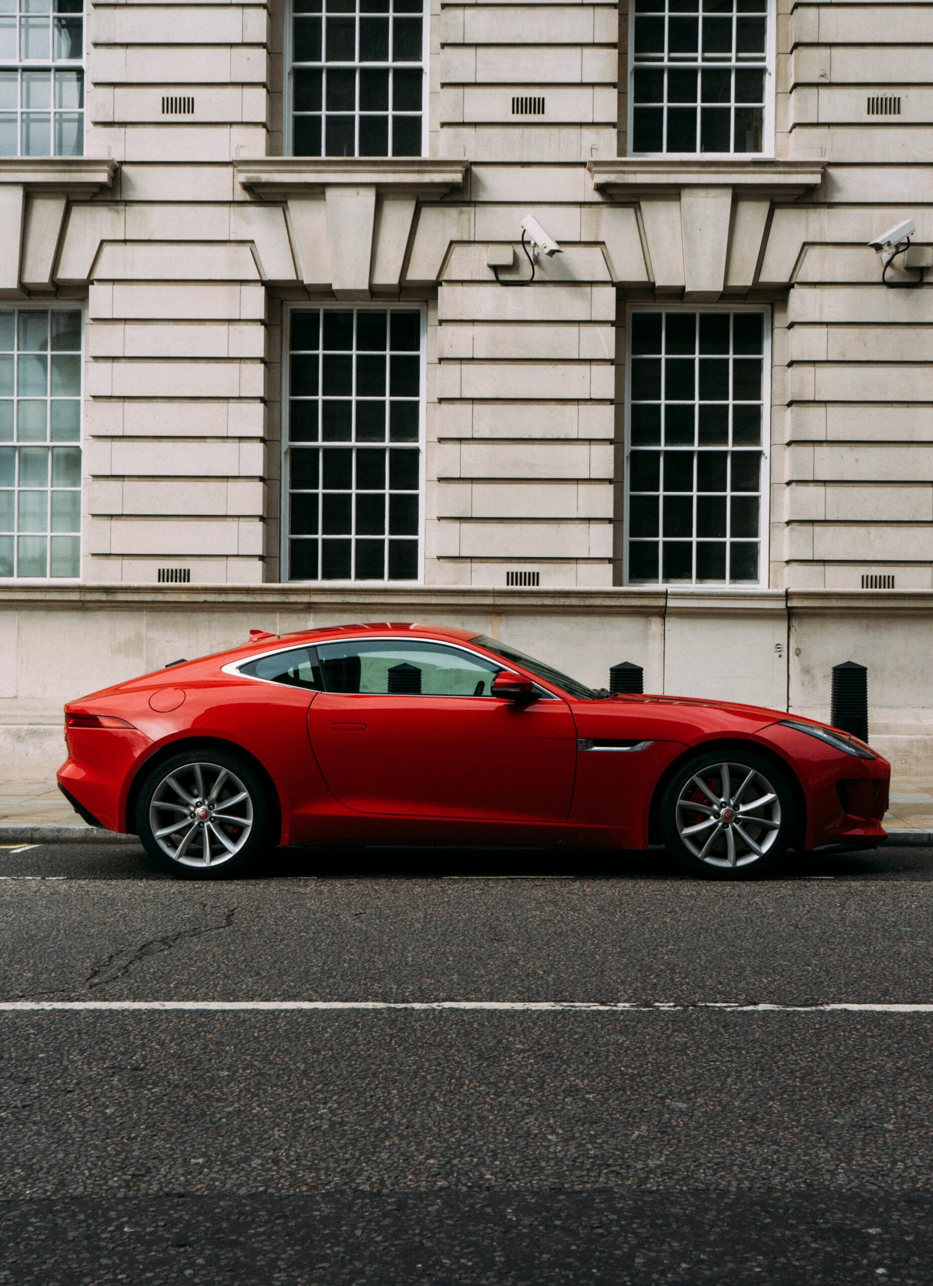 This image represents 'Xがあります,' showing a red car in front of a building.
