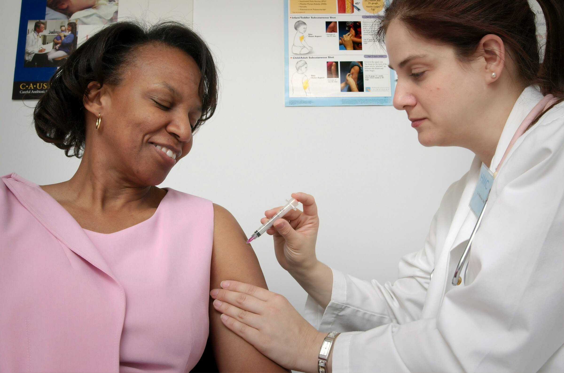 A woman receiving an injection from a doctor. This image represents a situation where the patient might use the phrase "-てもいいですか" to ask for permission, such as asking, "May I take a bath?" (Ofuro ni haitte mo ii desu ka).
