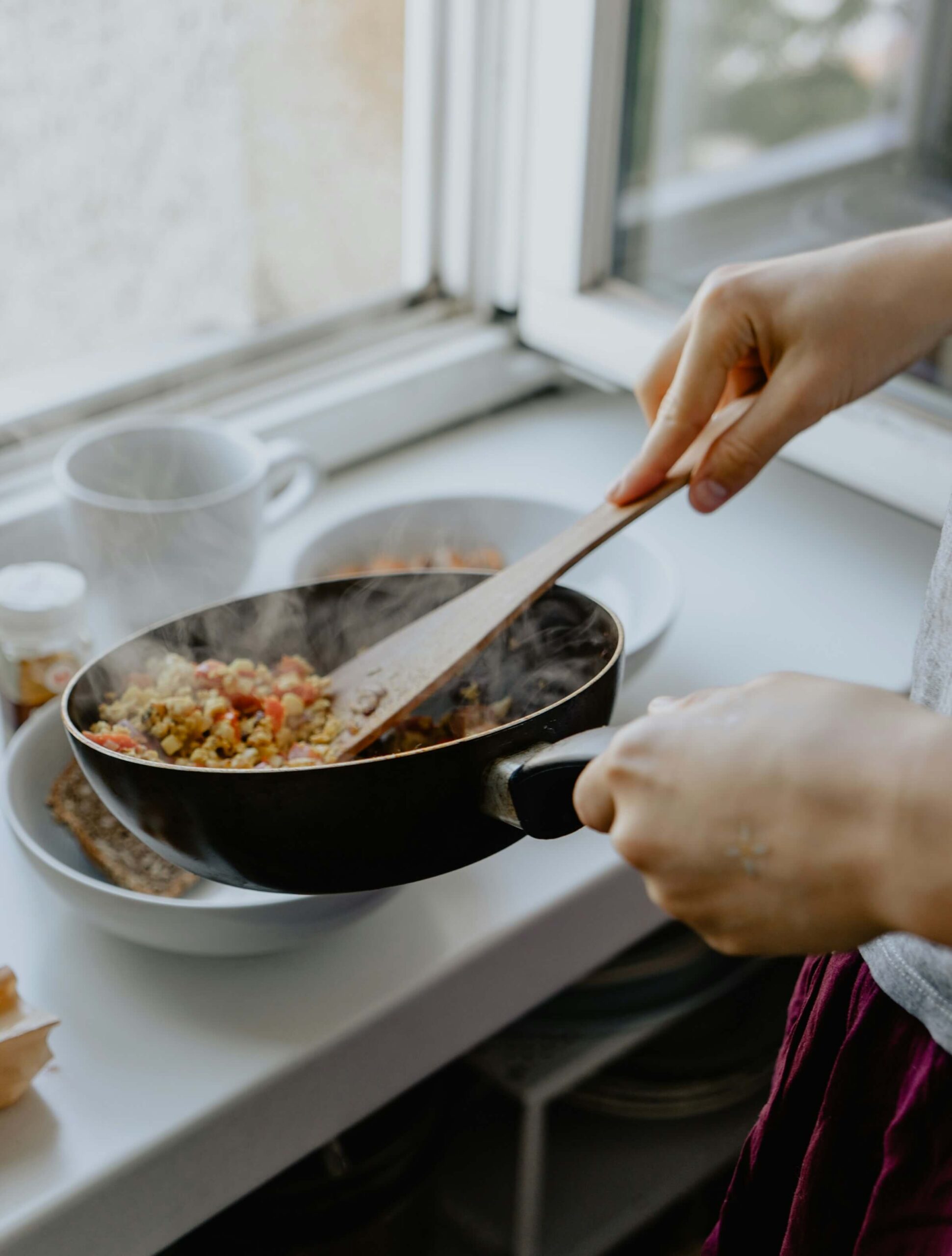 This image shows a person cooking, illustrating the phrase "Aさんは料理が上手です" (A-san wa ryouri ga jouzu desu), which means "A is good at cooking."
