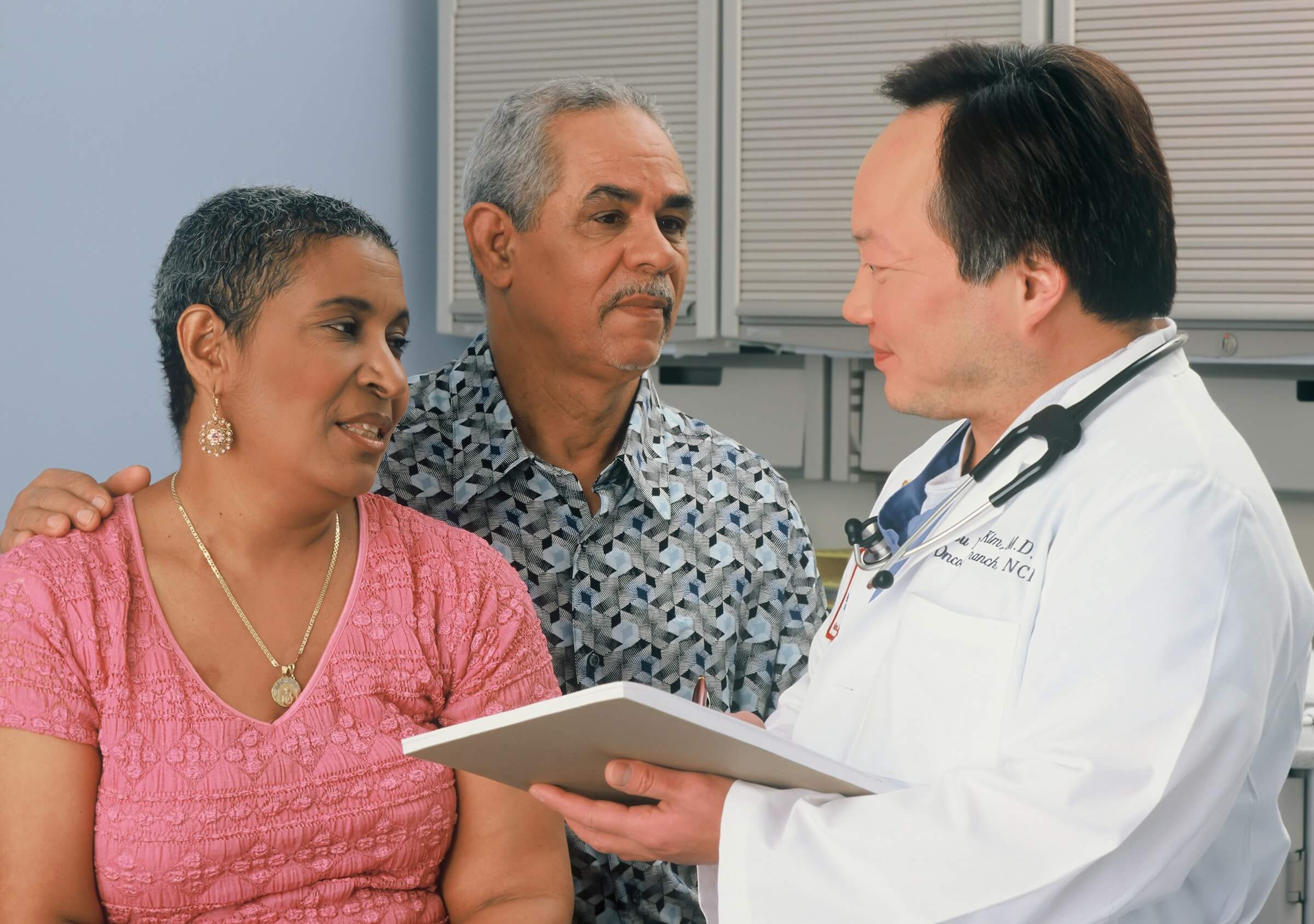 This image illustrates the use of "んです" (ndesu). A patient is explaining to the doctor why something happened to them, while another person, possibly a family member, is listening attentively.
