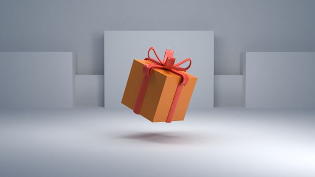 This image shows a levitating orange gift box with a red ribbon, set against a minimalistic gray background with soft shadows. The gift is prominently displayed in the center, symbolizing the theme of gift-giving, possibly in a context like the one discussed in the article "Understanding Gift-Giving in Japan," highlighting the cultural importance and thoughtful nature of presenting gifts in Japanese society.
